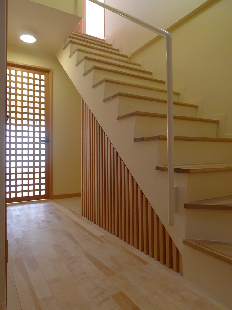 Cette photo montre un escalier droit asiatique avec des marches en bois et éclairage.