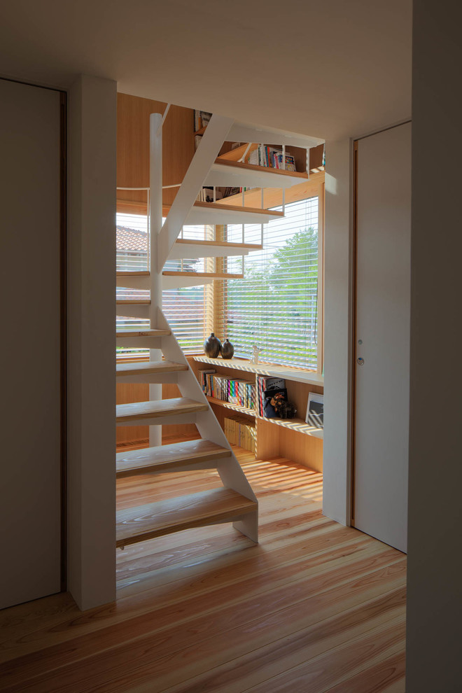 Idée de décoration pour un escalier sans contremarche hélicoïdal nordique de taille moyenne avec des marches en bois et un garde-corps en métal.