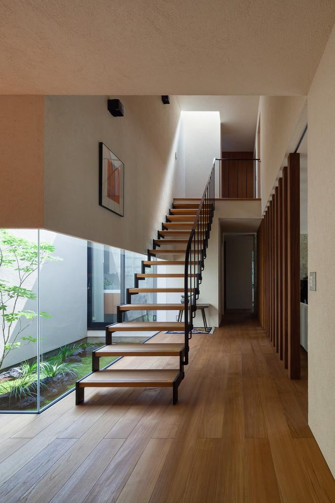 Foto de escalera recta minimalista sin contrahuella con escalones de madera y barandilla de metal