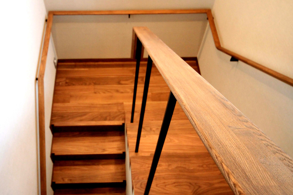 他の地域にある中くらいなトラディショナルスタイルのおしゃれな折り返し階段 (木の蹴込み板、金属の手すり) の写真