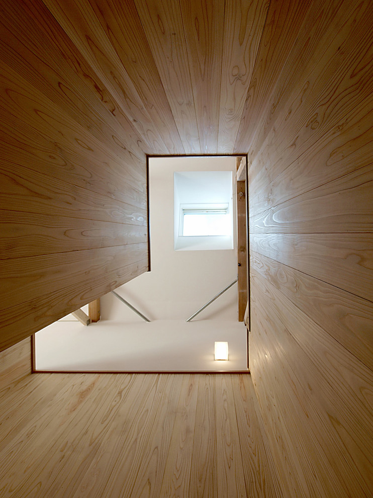 На фото: п-образная деревянная лестница в скандинавском стиле с деревянными ступенями и деревянными перилами с