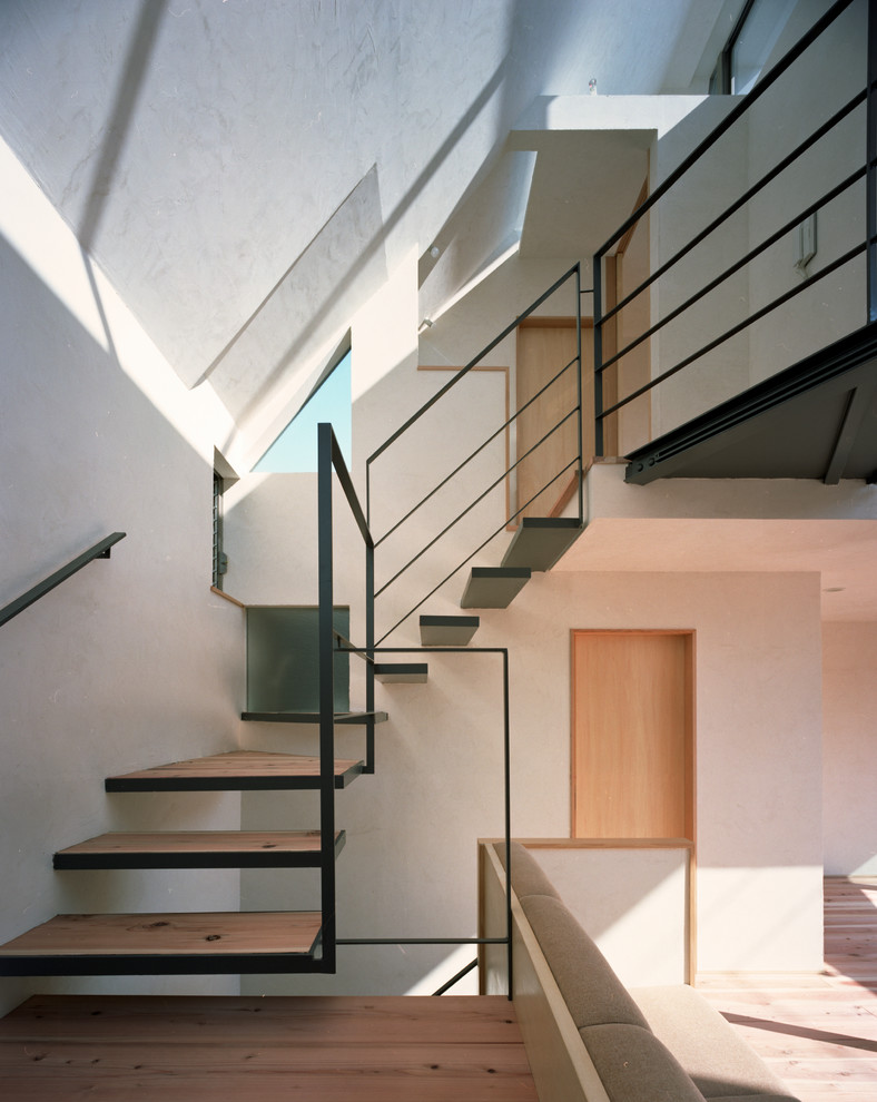 Imagen de escalera suspendida de estilo zen grande sin contrahuella con escalones de madera y barandilla de metal