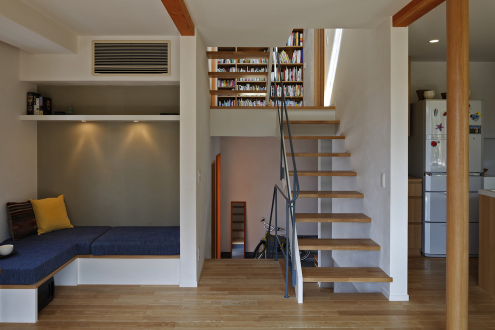 Cette image montre un escalier sans contremarche design en U avec des marches en bois et un garde-corps en métal.