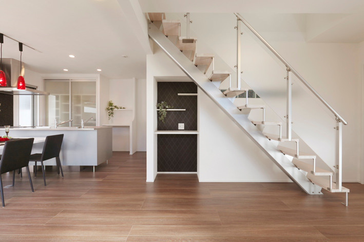 Ejemplo de escalera recta minimalista de tamaño medio con escalones de madera y barandilla de metal