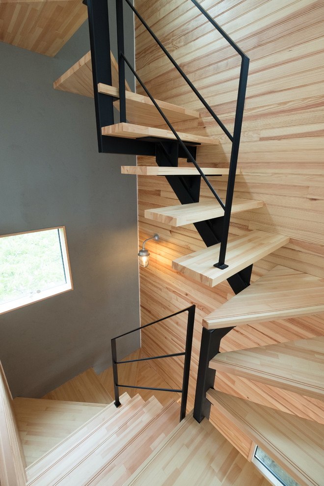 Exempel på en modern u-trappa i trä, med öppna sättsteg och räcke i metall