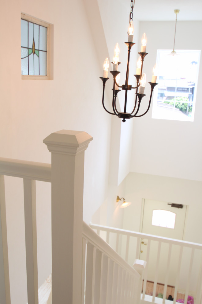 Imagen de escalera en U romántica con escalones de madera, contrahuellas de madera, barandilla de madera y papel pintado