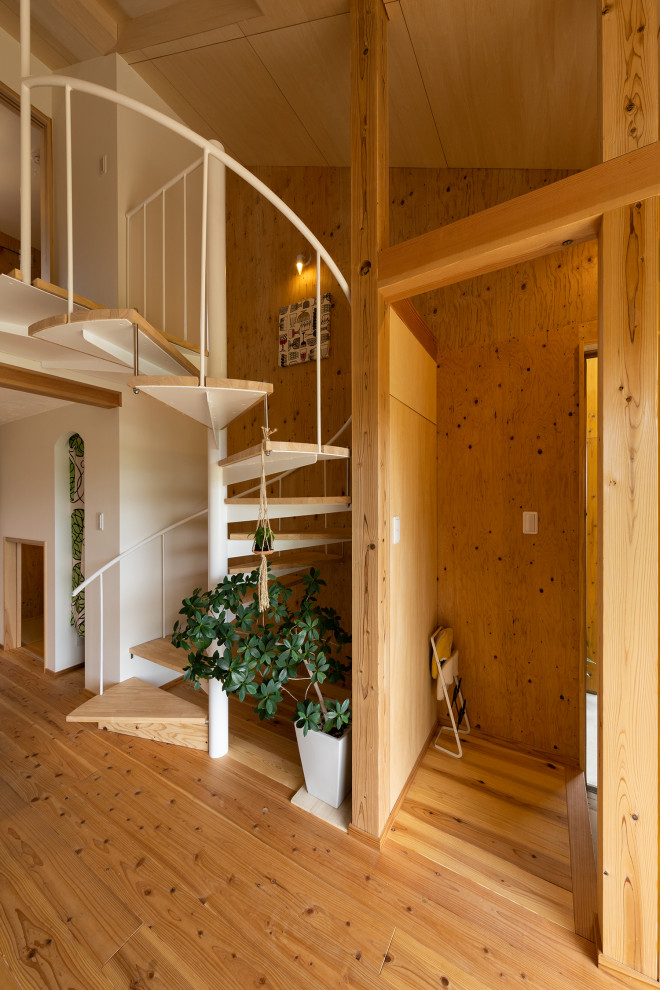 Exemple d'un petit escalier hélicoïdal asiatique avec des marches en bois et un garde-corps en métal.