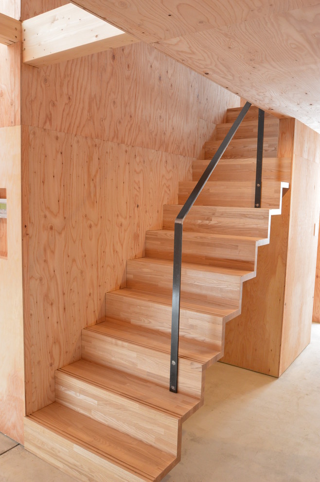 Cette image montre un petit escalier droit minimaliste avec des marches en bois, des contremarches en bois et un garde-corps en métal.