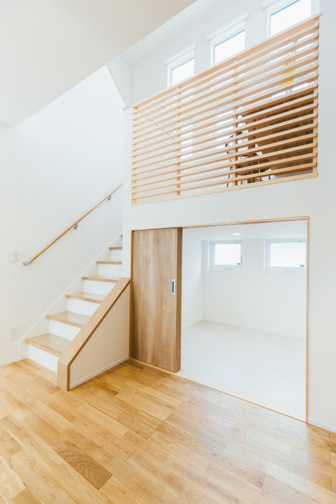 Idée de décoration pour un escalier nordique en U de taille moyenne avec des marches en bois, des contremarches en bois et un garde-corps en bois.