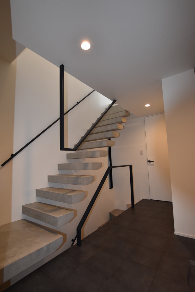 Inspiration for an industrial concrete straight open and metal railing staircase remodel in Other