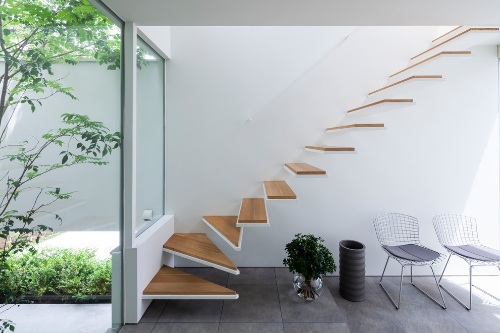 На фото: прямая лестница в стиле лофт с деревянными ступенями без подступенок с
