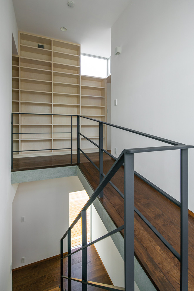 Cette photo montre un escalier sans contremarche droit asiatique de taille moyenne avec des marches en bois et un garde-corps en métal.