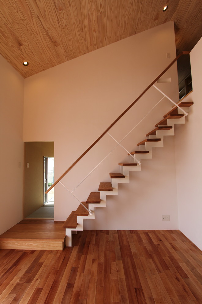Imagen de escalera recta minimalista sin contrahuella con escalones de madera y barandilla de varios materiales