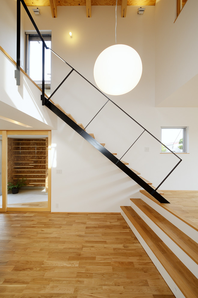 Пример оригинального дизайна: большая прямая лестница в скандинавском стиле с деревянными ступенями, металлическими перилами и обоями на стенах без подступенок