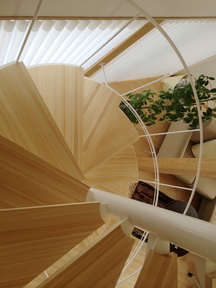 Inspiration pour un petit escalier sans contremarche hélicoïdal nordique avec des marches en bois et un garde-corps en métal.