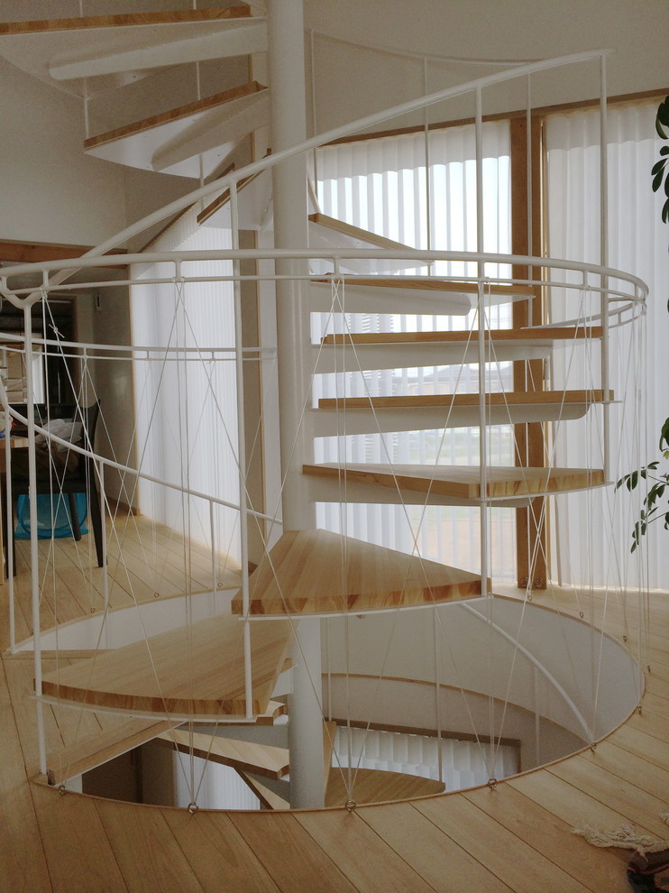 Inspiration pour un petit escalier sans contremarche hélicoïdal nordique avec des marches en bois et un garde-corps en métal.
