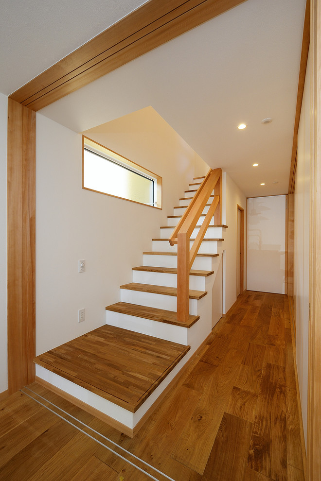 Пример оригинального дизайна: прямая деревянная лестница в скандинавском стиле с деревянными ступенями, деревянными перилами и обоями на стенах