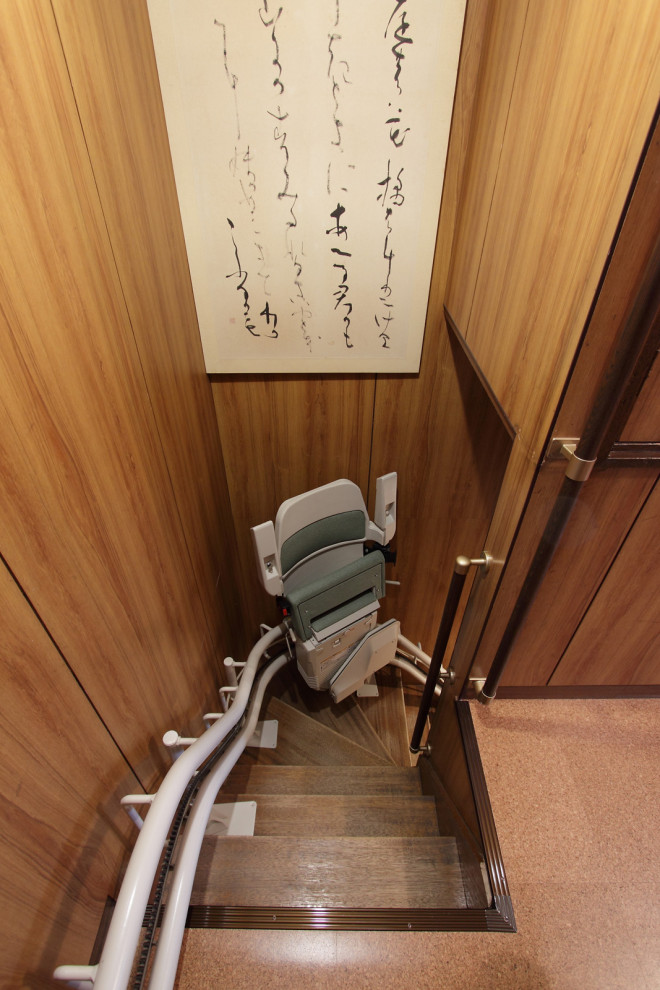 京都にある高級な小さなアジアンスタイルのおしゃれなかね折れ階段 (木の蹴込み板、金属の手すり) の写真
