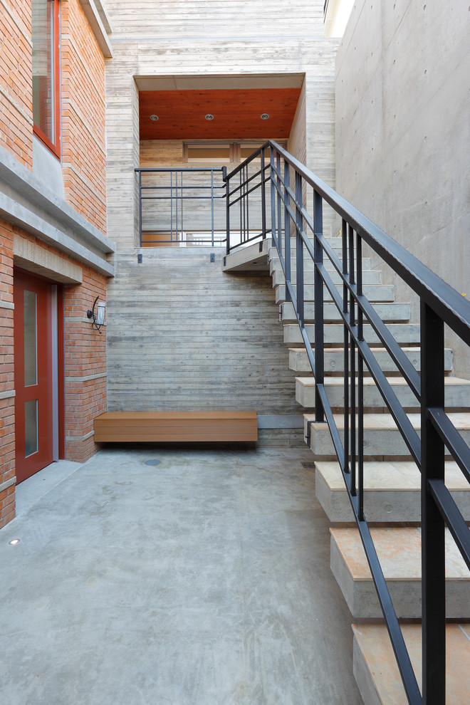 Стильный дизайн: прямая лестница в стиле модернизм с бетонными ступенями и металлическими перилами без подступенок - последний тренд