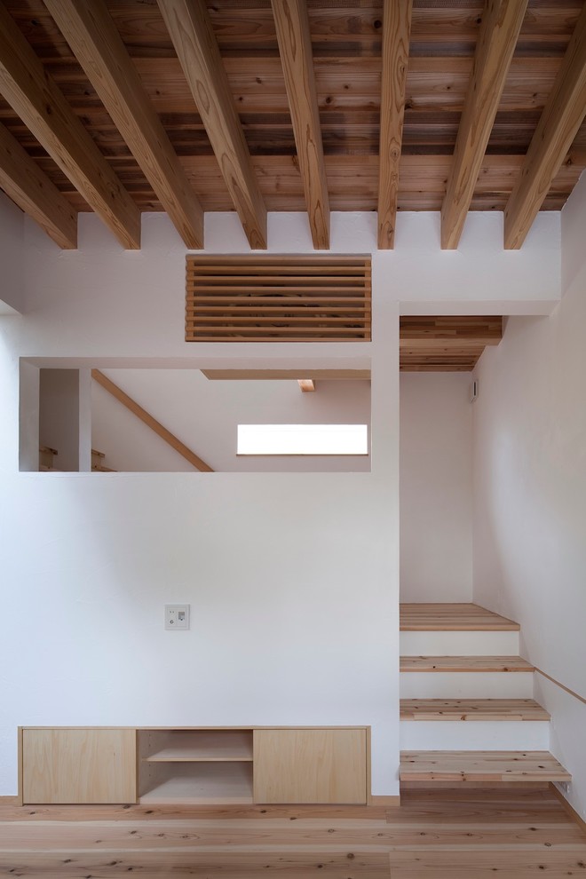 На фото: деревянная лестница в стиле модернизм с деревянными ступенями и деревянными перилами