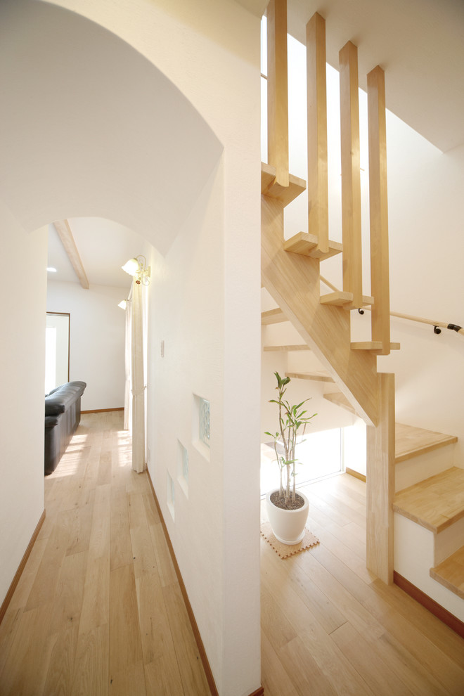 Свежая идея для дизайна: изогнутая лестница в восточном стиле с деревянными ступенями и деревянными перилами - отличное фото интерьера