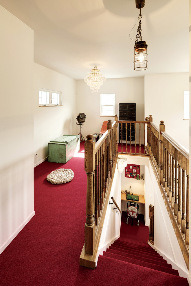 This is an example of a medium sized nautical carpeted straight wood railing staircase in Other with carpeted risers.