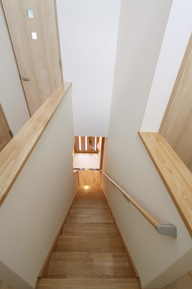 Foto de escalera recta con escalones de madera, contrahuellas de madera y barandilla de madera