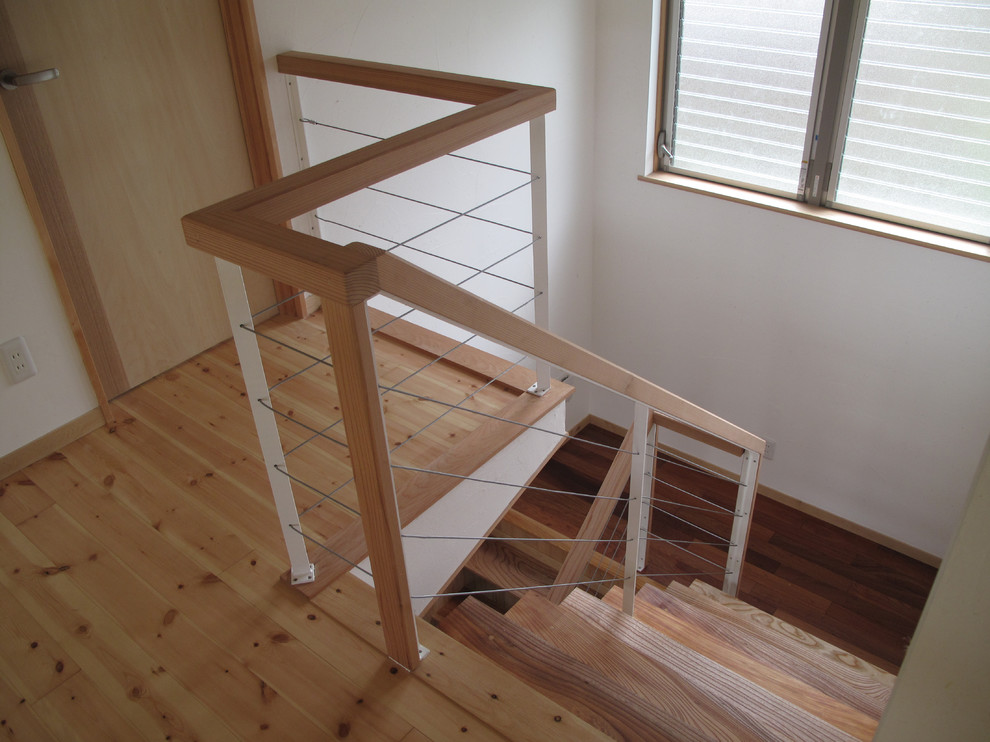 他の地域にある中くらいな北欧スタイルのおしゃれな階段 (木材の手すり) の写真