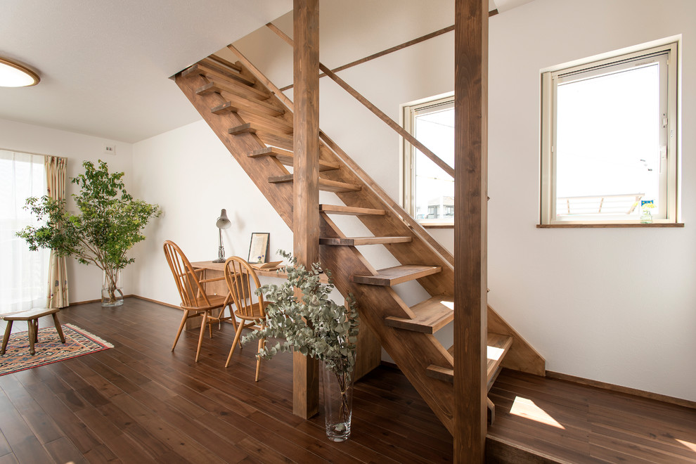 Exempel på en lantlig rak trappa i trä, med öppna sättsteg och räcke i trä