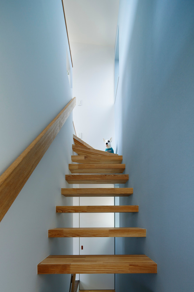 Immagine di una scala a "L" minimalista di medie dimensioni con pedata in legno e nessuna alzata