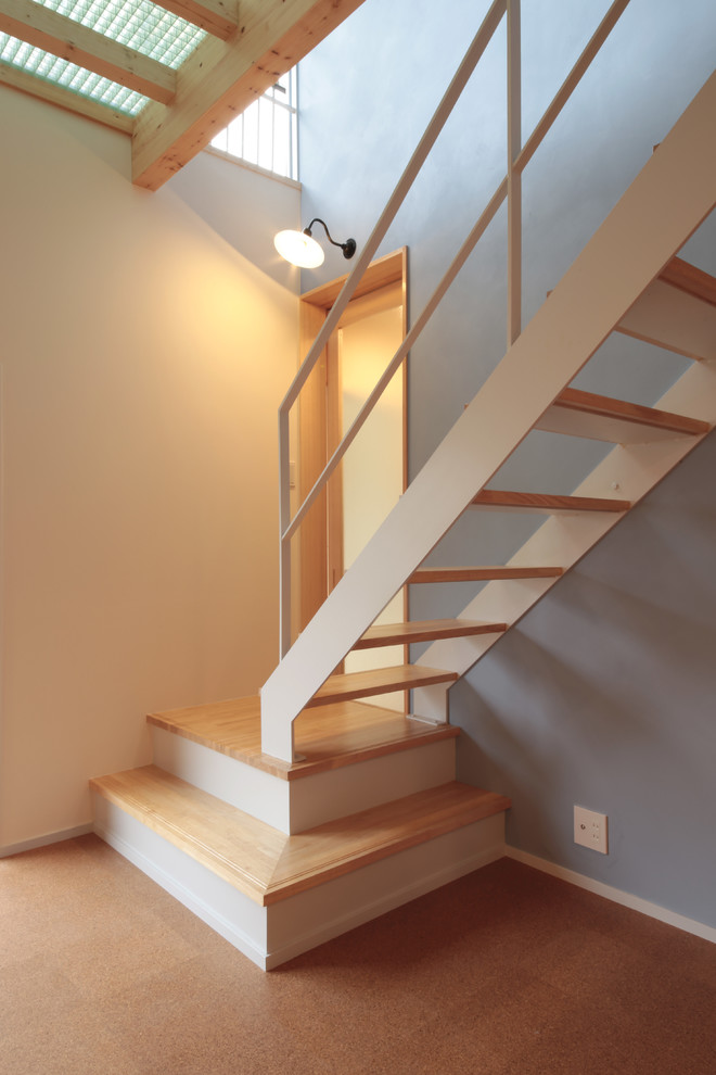 This is an example of a medium sized world-inspired wood l-shaped metal railing staircase in Other with open risers.