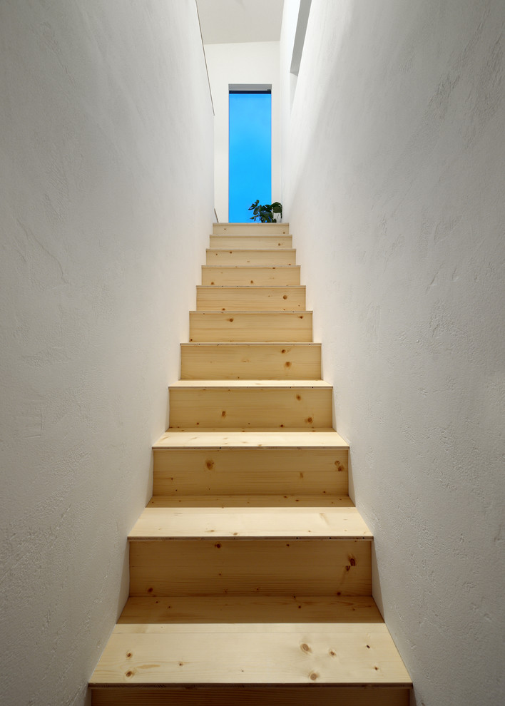 Photo of a modern wood staircase in Other with wood risers.